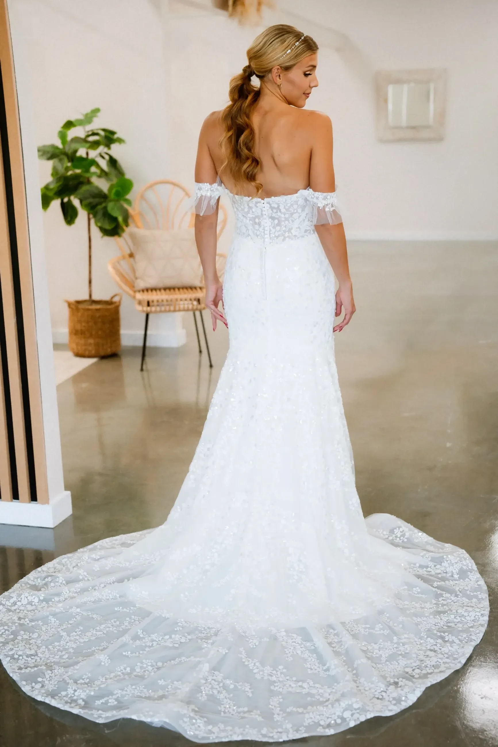 model is wearing an off the shoulder fit and flare wedding dress